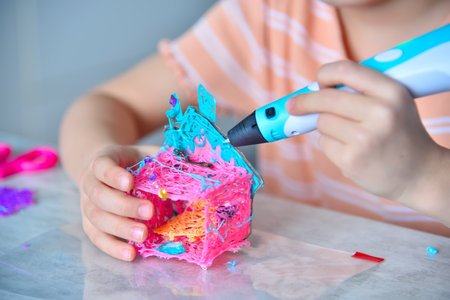 Young girl designer using 3d printing pen at home. Creativity and innovation in art concept. Close upの写真素材