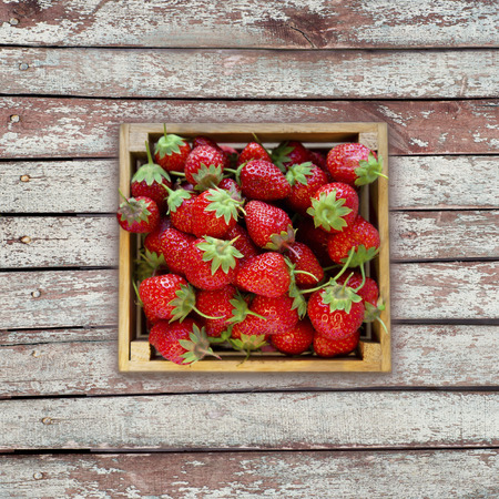 Strawberries in a wooden box. Top view. Ripe strawberries on a wooden background. Sweet and juicy berry with copy space for text. Top view.の写真素材