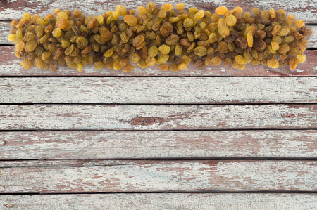 Background made of raisins. Dried fruit with copy space for text. The scattered of a raisins on a wooden background. Top view.の写真素材