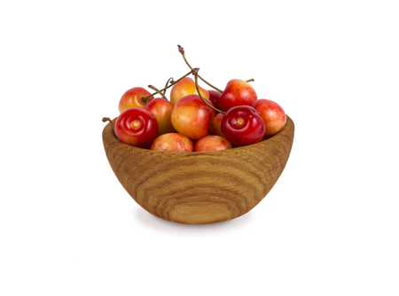 cherry in a wooden bowl isolated on white background. Ripe cherry close-up. Background berry. Sweet and juicy berry with copy space for text. の写真素材