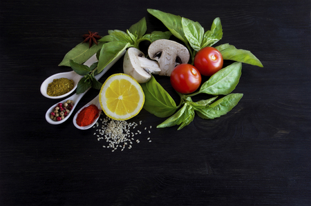 vegetables and spices on a black wooden backgroundの写真素材