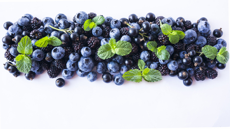 Black and blue berries isolated on a white. Ripe blueberries, blackberries with mint on white background. Berries with copy space for text. Background berries. Top view.の写真素材