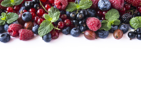 Mix fruits berries isolated on white background. Ripe currants, raspberries, blueberries, gooseberrie, blackberries with a mint leaf. Sweet and juicy fruits with copy space for text. Various fresh summer. Background of mix fruits on a white background. Top view.の写真素材