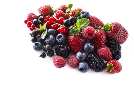 Fruits and berries isolated on white background. Ripe currants, raspberries, blueberries, strawberries and blackberries with a mint leaf. Sweet and juicy fruits with copy space for text. Various fresh summer. Background of mix fruits on a white background. Top view.の写真素材