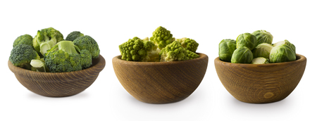 Different kinds of cabbage in a wooden bowl. Broccoli, Brussels sprouts, Roman cauliflower isolated on white background. Ð¡abbage with copy space for text. Green food on a white background. Green vegetables isolated on a white. Collage of different vegetables at green color. The best vegetables for dinner.の写真素材