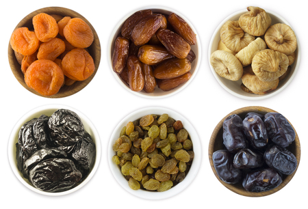 Collage of different dried fruits. Dried prunes, dried apricots, raisins, dates, figs isolated on white background. Top view. Dried fruits isolated on a white background. Dried fruits in a bowl on white background. Dried fruits with copy space for text.の写真素材