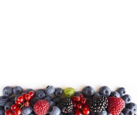Mix berries isolated on a white background. Fresh blueberries, raspberries, red currants, blackberries, gooseberries . Top view. Fruits with copy space for text. Background berries and fruits. Background of mix berries and fruits. Various fresh summer fruits.の写真素材