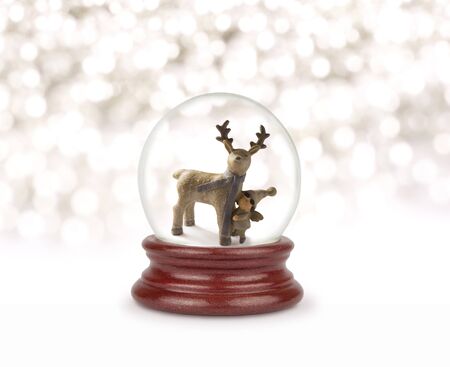 Christmas snow globe on white. Can be used as a Christmas or a New Year gift or symbol. Christmas and New Year design element. Toy glass snow globe with deer and baby. Snow ball on white.の写真素材
