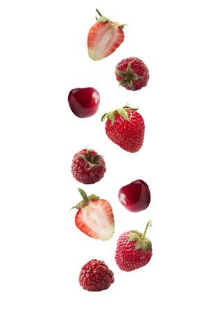 Isolated fresh berries float in the air. Falling strawberry, raspberry, cherry isolated on white background  . Mixed berries with a copy space for text. Collage of whole red berries.の写真素材