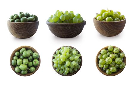 Green fruits isolated on a white background. Collage of different fruits and berries at green color.Green baby kiwi fruit actinidia, gooseberry, green grapes in a wooden bowl. Fruit and berry on whiteの写真素材