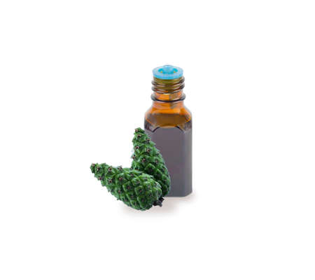 A bottle with fir tree essential oil. Spruce needle branch with cone. Aromatherapy, perfumery, cosmetics. Essential oil fir tree isolated on white background. Essential oil aromatherapy, spruce cone.の写真素材