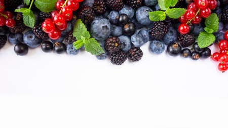 Ripe raspberries, blueberries, blackberries, red and blackcurrants on white background. Background of mix fruits with copy space for text. Mix berries on white background.の写真素材