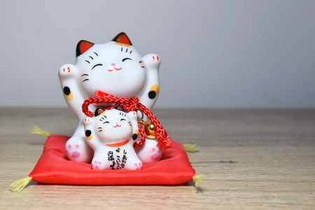 Maneki-neko is a common Japanese figurine (beckoning cat)の写真素材
