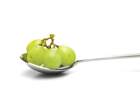 Grapes on a spoon isolated against a white backgroundの写真素材