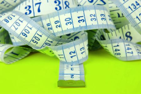 A measuring tape isolated agaist a lime green background