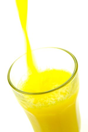 Orange juice being poured into a glass isolated against a white backgroundの写真素材