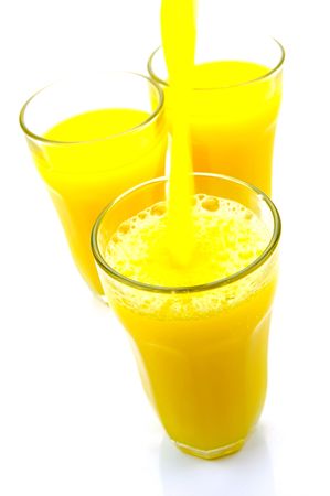 Orange juice being poured into a glass isolated against a white backgroundの写真素材