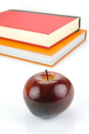 A red apple isolated on a white background with school booksの写真素材