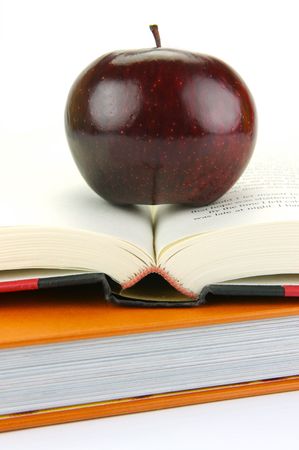 A red apple isolated on a white background with school booksの写真素材