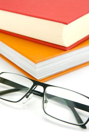 Reading glasses and books isolated against a white backgroundの写真素材
