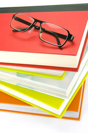 Reading glasses and books isolated against a white backgroundの写真素材