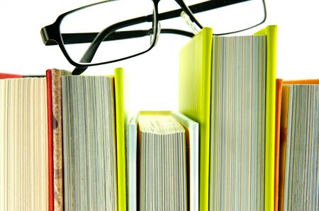 Reading glasses and books isolated against a white backgroundの写真素材
