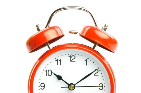 An old fahion analogue alarm clock set against a white backgroundの写真素材