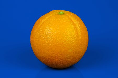 An orange isolated against a blue backgroundの写真素材