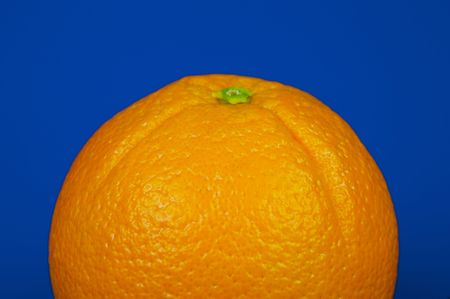 An orange isolated against a blue backgroundの写真素材