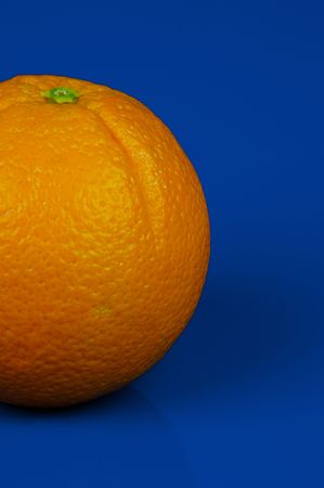 An orange isolated against a blue backgroundの写真素材