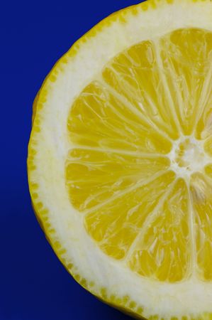 A sliced lemon isolated against a blue backgroundの写真素材
