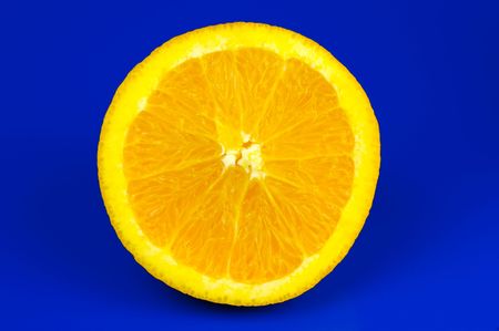 A sliced orange isolated against a blue backgroundの写真素材