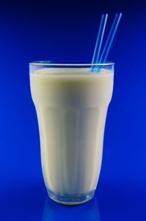 A glass of milk isolated against a blue backgroundの写真素材