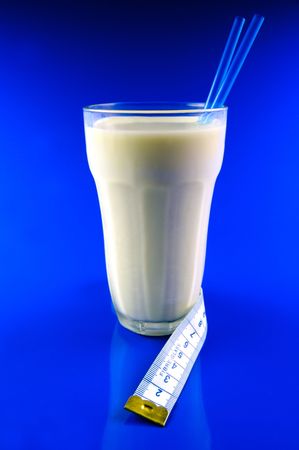 A glass of milk isolated against a blue backgroundの写真素材
