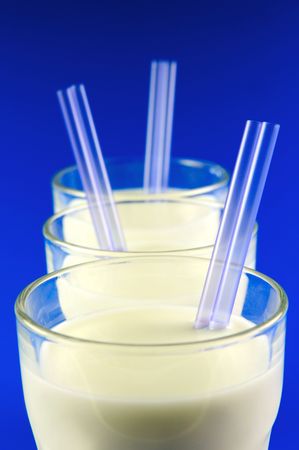 A glass of milk isolated against a blue backgroundの写真素材