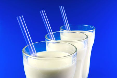 A glass of milk isolated against a blue backgroundの写真素材