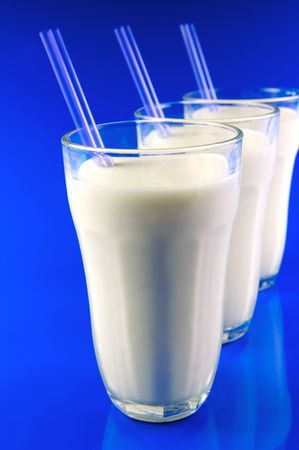 A glass of milk isolated against a blue backgroundの写真素材