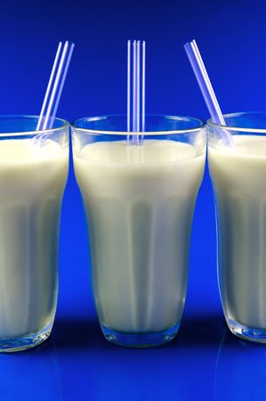 A glass of milk isolated against a blue backgroundの写真素材