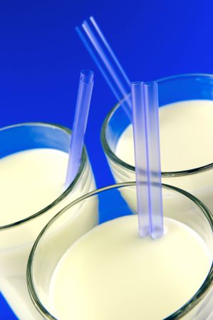 A glass of milk isolated against a blue backgroundの写真素材