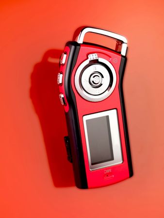 An MP3 player isolated against a red background