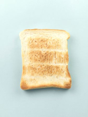 Plain white toast isolated against a pale blue backgroundの写真素材