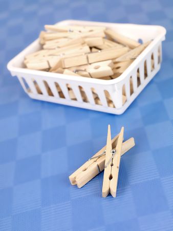 Laundry pegs isolated against a blue background の写真素材