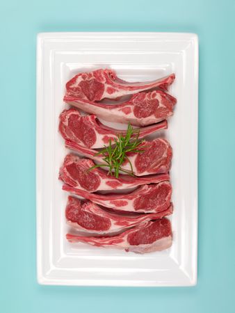 Lamb chops on a plate isolated against a blue backgroundの写真素材