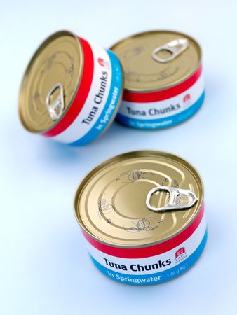 Cans of Tuna isolated against a blue backgroundの写真素材