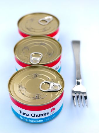 Cans of Tuna isolated against a blue backgroundの写真素材