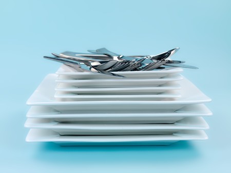 Plates and cutlery isolated against a blue backgroundの写真素材