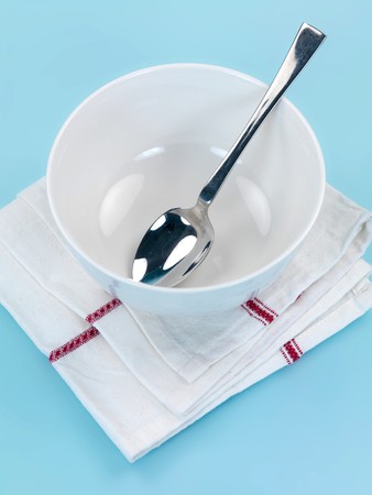 Plates and cutlery isolated against a blue backgroundの写真素材