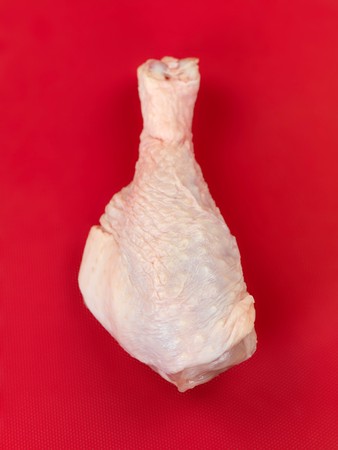 Raw chicken drumsticks on a kitchen benchの写真素材