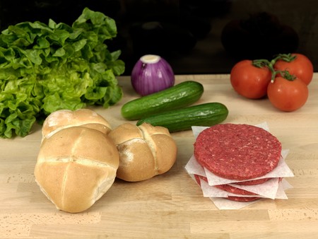raw hamburger patties on a kitchen benchの写真素材