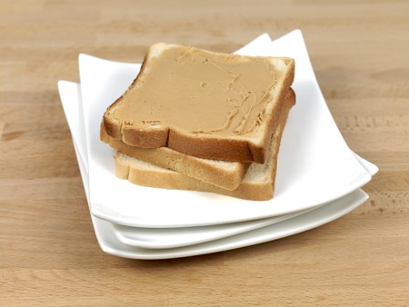 A slice of white bread with peanut butter